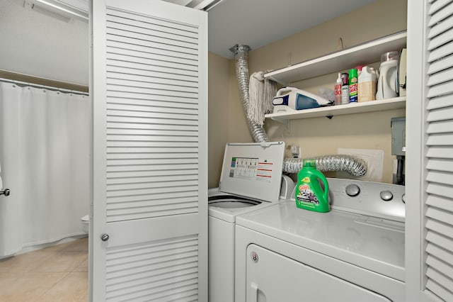 laundry area with light tile patterned floors and washer and clothes dryer