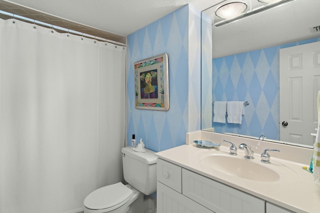 bathroom with vanity, a textured ceiling, and toilet