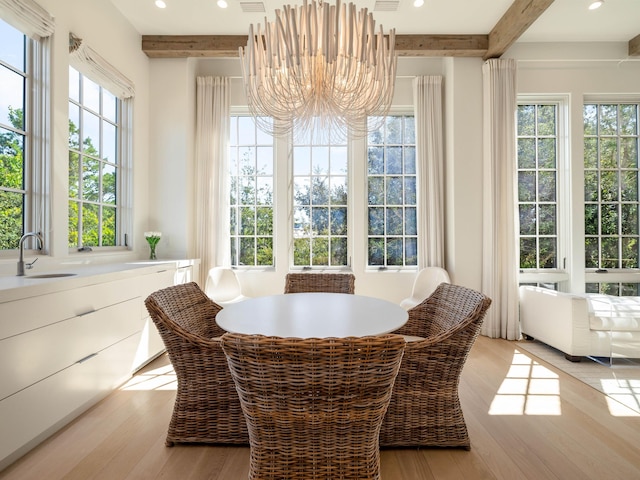 sunroom / solarium with an inviting chandelier, sink, and beamed ceiling