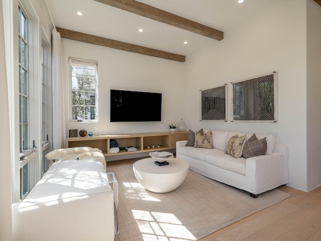 living room with beamed ceiling and light hardwood / wood-style floors