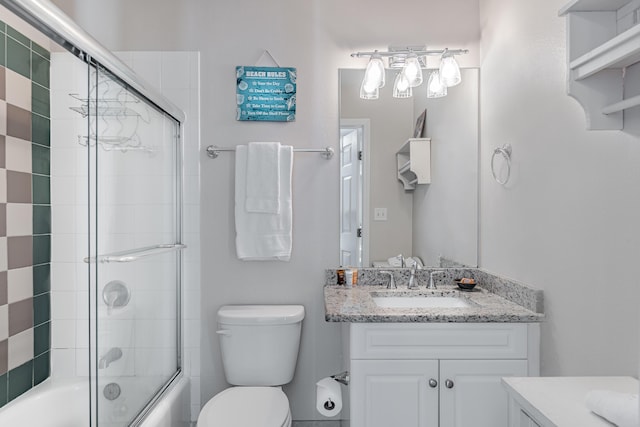 full bathroom featuring vanity, shower / bath combination with glass door, and toilet