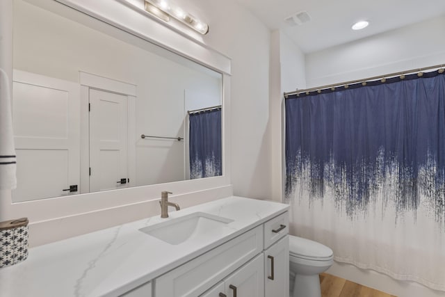 full bathroom with vanity, hardwood / wood-style floors, toilet, and shower / bathtub combination with curtain