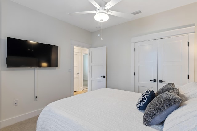 bedroom with light carpet, ceiling fan, and a closet