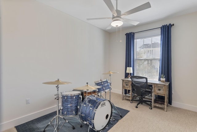 carpeted home office featuring ceiling fan