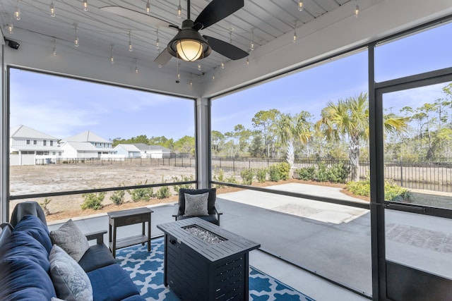 sunroom / solarium featuring ceiling fan and rail lighting