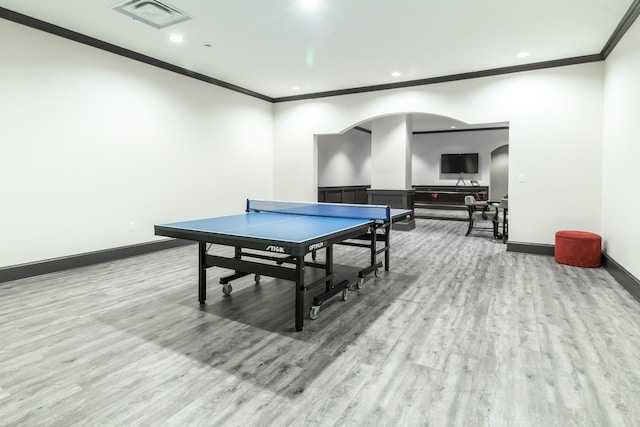 playroom with ornamental molding and light wood-type flooring