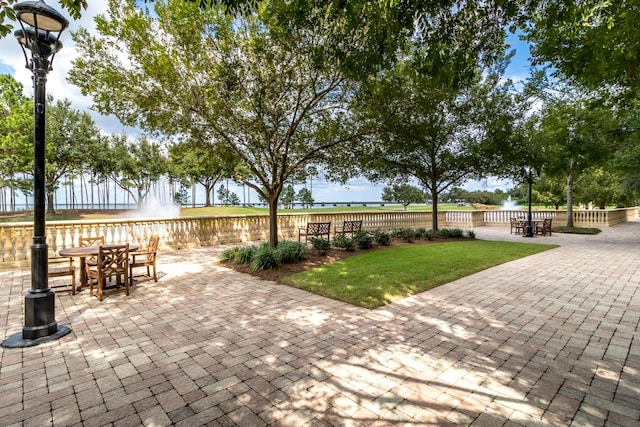 view of property's community featuring a yard and a patio