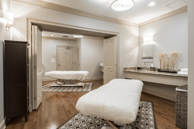 bathroom with ornamental molding, sink, and wood-type flooring