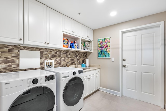 laundry area with cabinets, washer and dryer, and sink