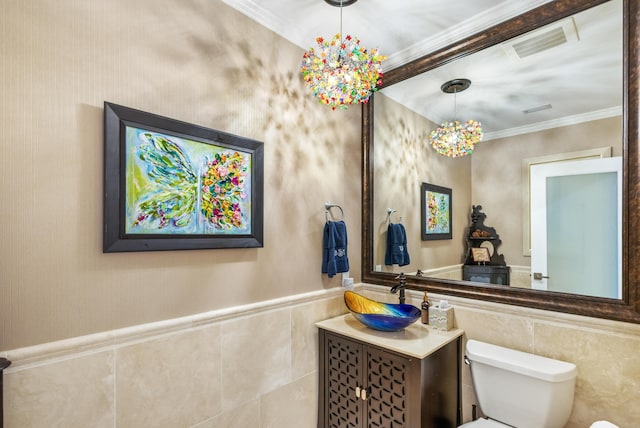 bathroom featuring vanity, crown molding, tile walls, and toilet