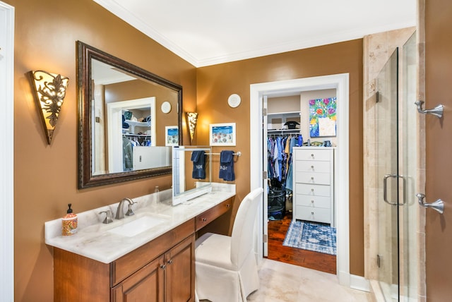 bathroom with vanity, crown molding, and a shower with shower door