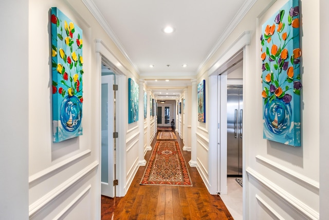 hallway with decorative columns, ornamental molding, dark hardwood / wood-style floors, and elevator