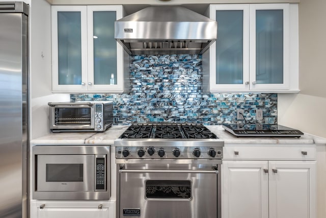 kitchen featuring ventilation hood, white cabinetry, tasteful backsplash, and stainless steel appliances