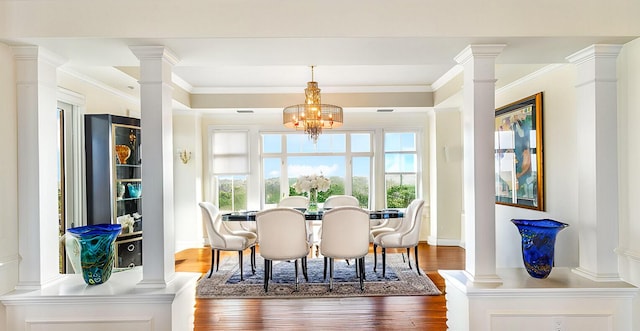 dining space with a notable chandelier, crown molding, dark hardwood / wood-style floors, and ornate columns