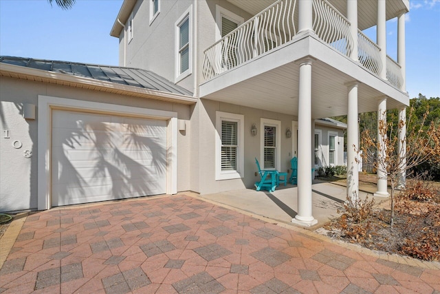 view of patio featuring a garage and a balcony