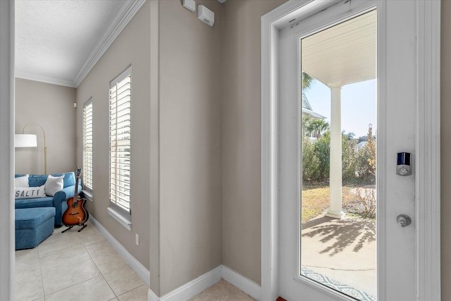 entryway with ornamental molding, a textured ceiling, and light tile patterned floors