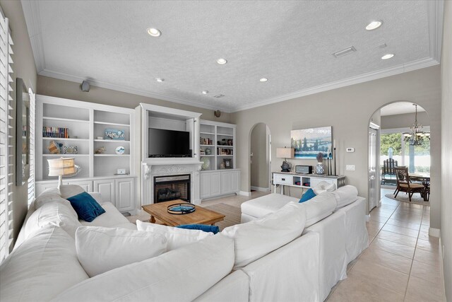 tiled living room featuring ornamental molding, a chandelier, and a textured ceiling