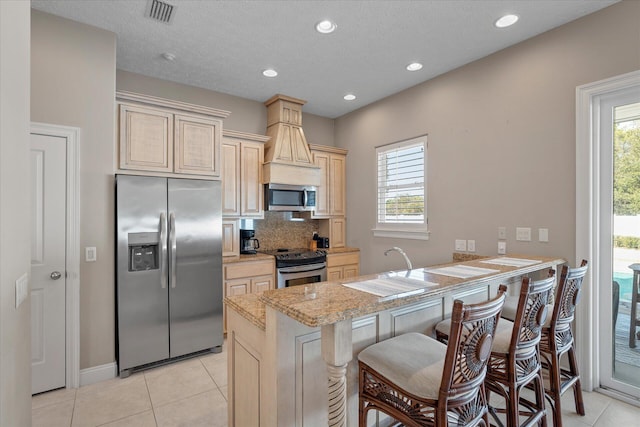 kitchen with stainless steel appliances, a healthy amount of sunlight, a kitchen bar, and kitchen peninsula