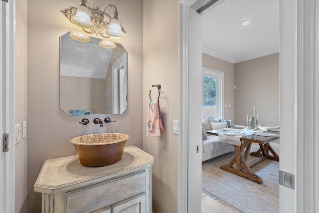 bathroom featuring vanity, a notable chandelier, and crown molding