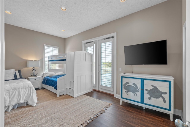 bedroom featuring hardwood / wood-style flooring, access to outside, and a textured ceiling