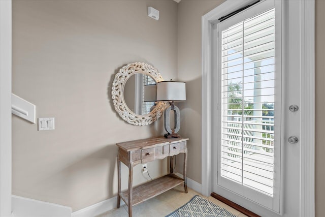 doorway to outside with light tile patterned flooring