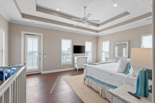 bedroom with dark wood-type flooring, ceiling fan, ornamental molding, and a raised ceiling