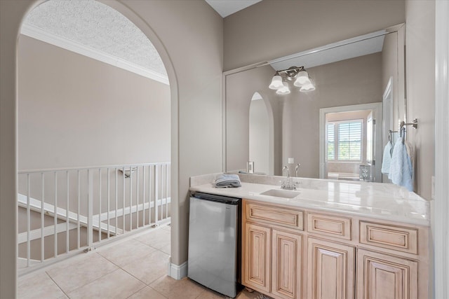 bathroom with vanity, ornamental molding, tile patterned floors, and a textured ceiling