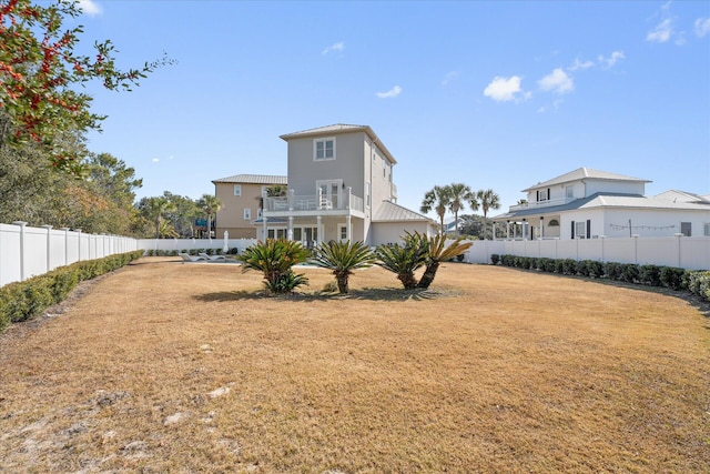 back of property featuring a balcony and a yard