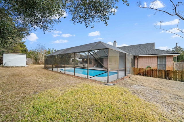 view of swimming pool featuring a yard and a storage unit