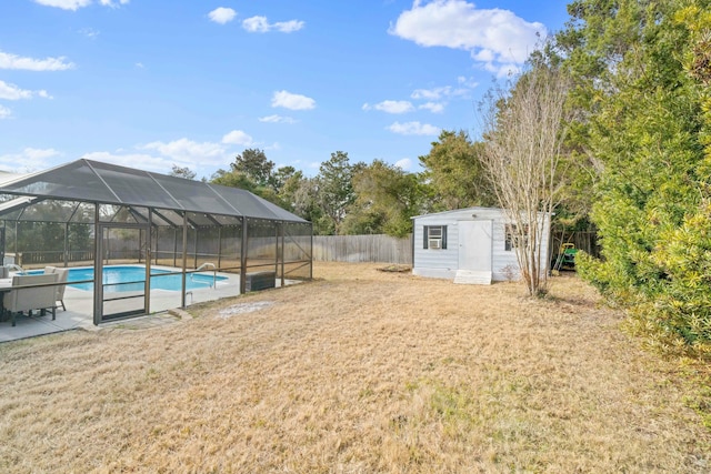 view of yard featuring a fenced in pool, a lanai, and a storage unit