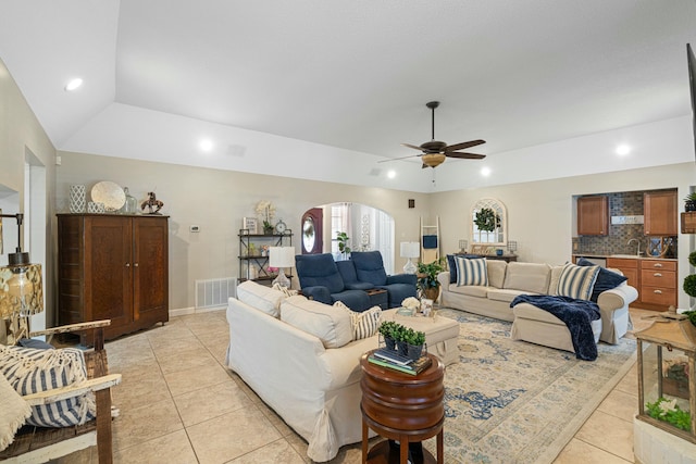 tiled living room featuring lofted ceiling, sink, ceiling fan, and a tray ceiling