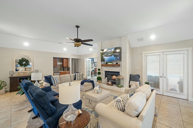 living room with vaulted ceiling, light tile patterned flooring, a brick fireplace, and ceiling fan