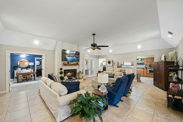 tiled living room with lofted ceiling, a brick fireplace, and ceiling fan