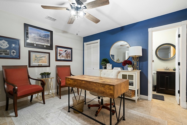 home office featuring ceiling fan, sink, and light tile patterned floors