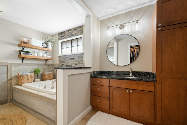 bathroom with vanity, a relaxing tiled tub, and tile patterned floors