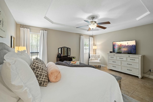 tiled bedroom featuring multiple windows, a textured ceiling, and ceiling fan