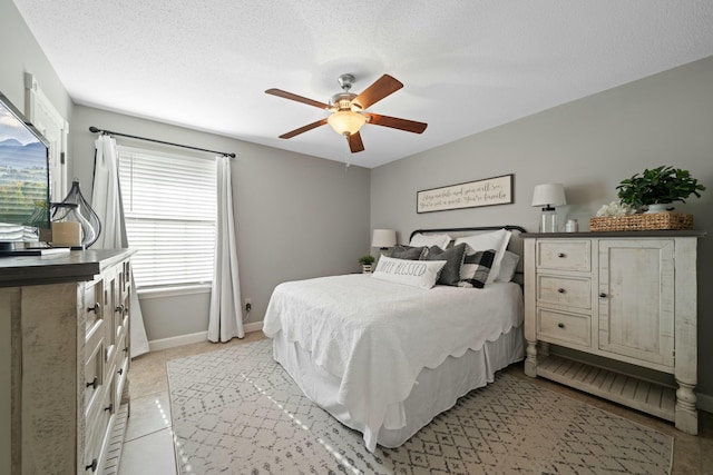 tiled bedroom featuring ceiling fan and a textured ceiling