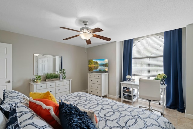 bedroom featuring light tile patterned flooring, ceiling fan, and a textured ceiling