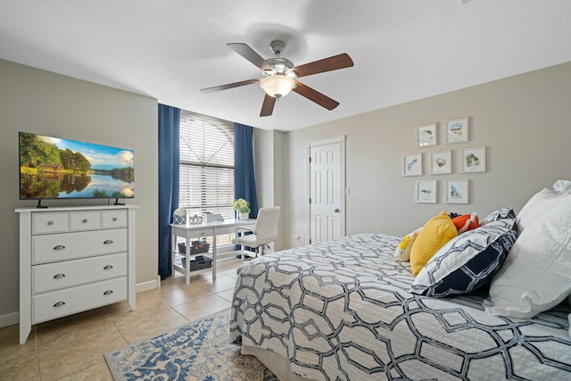 tiled bedroom with ceiling fan and a textured ceiling