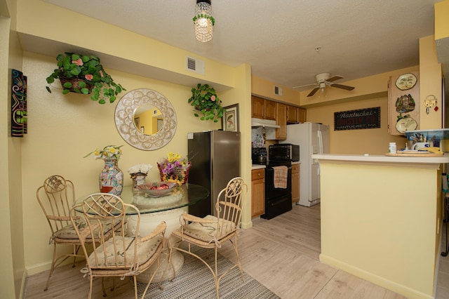 kitchen with ceiling fan, kitchen peninsula, light wood-type flooring, and black appliances