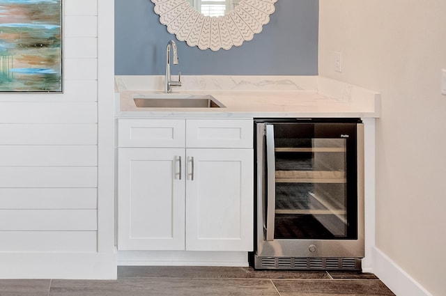 bar featuring wine cooler, dark hardwood / wood-style flooring, sink, and white cabinets