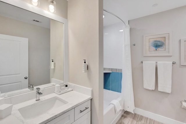 bathroom featuring hardwood / wood-style flooring, shower / tub combo with curtain, and vanity