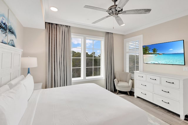 bedroom with light hardwood / wood-style flooring, ornamental molding, and ceiling fan