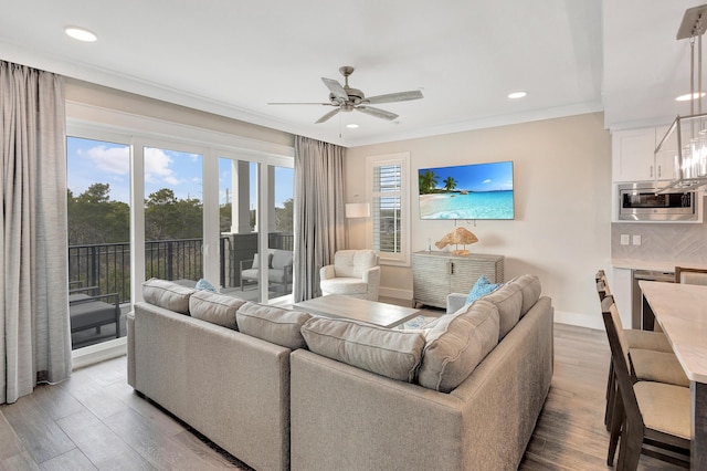 living room with crown molding, ceiling fan, and light hardwood / wood-style floors