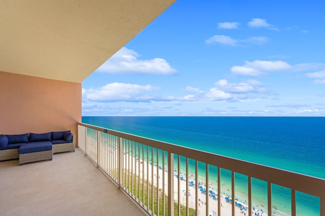 balcony featuring a water view, outdoor lounge area, and a view of the beach