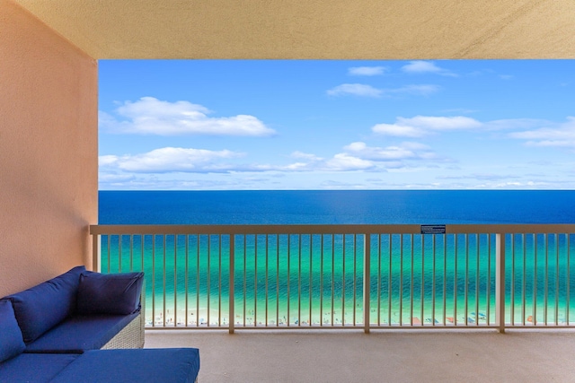 balcony featuring a beach view and a water view