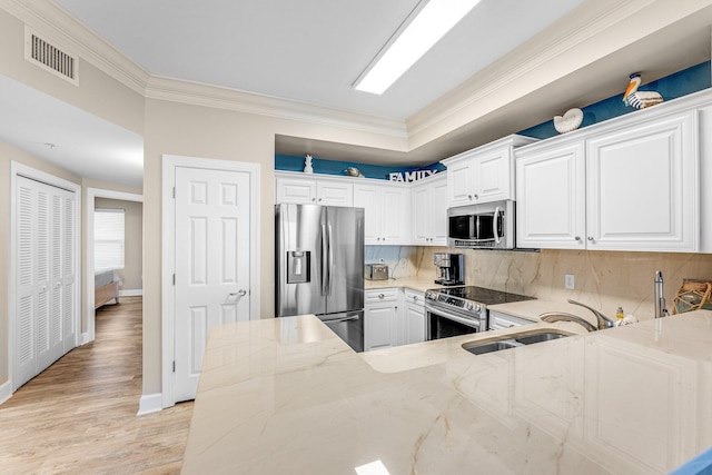 kitchen featuring white cabinetry, ornamental molding, and stainless steel appliances