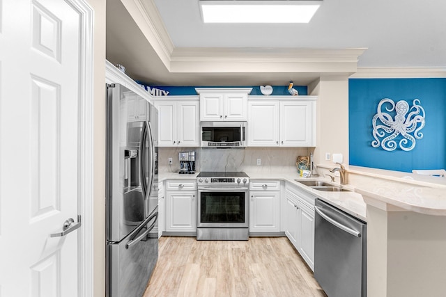 kitchen with sink, crown molding, stainless steel appliances, and white cabinets