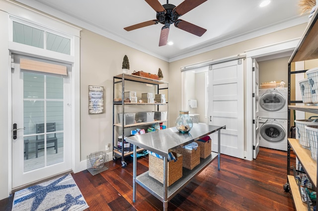 interior space featuring crown molding, wood-type flooring, a barn door, a ceiling fan, and stacked washing maching and dryer