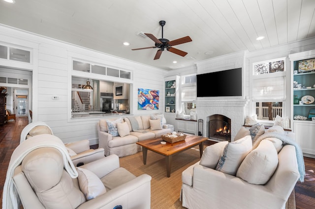 living area featuring ceiling fan, recessed lighting, a fireplace, built in features, and crown molding